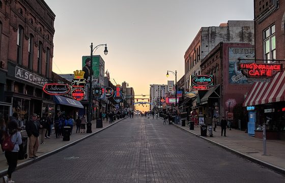 Beale Street at dusk, its neon signs lit along the block
