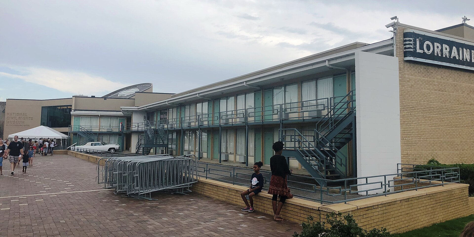 The Lorraine Motel at the National Civil Rights Museum, with visitors resting on a low brick wall outside