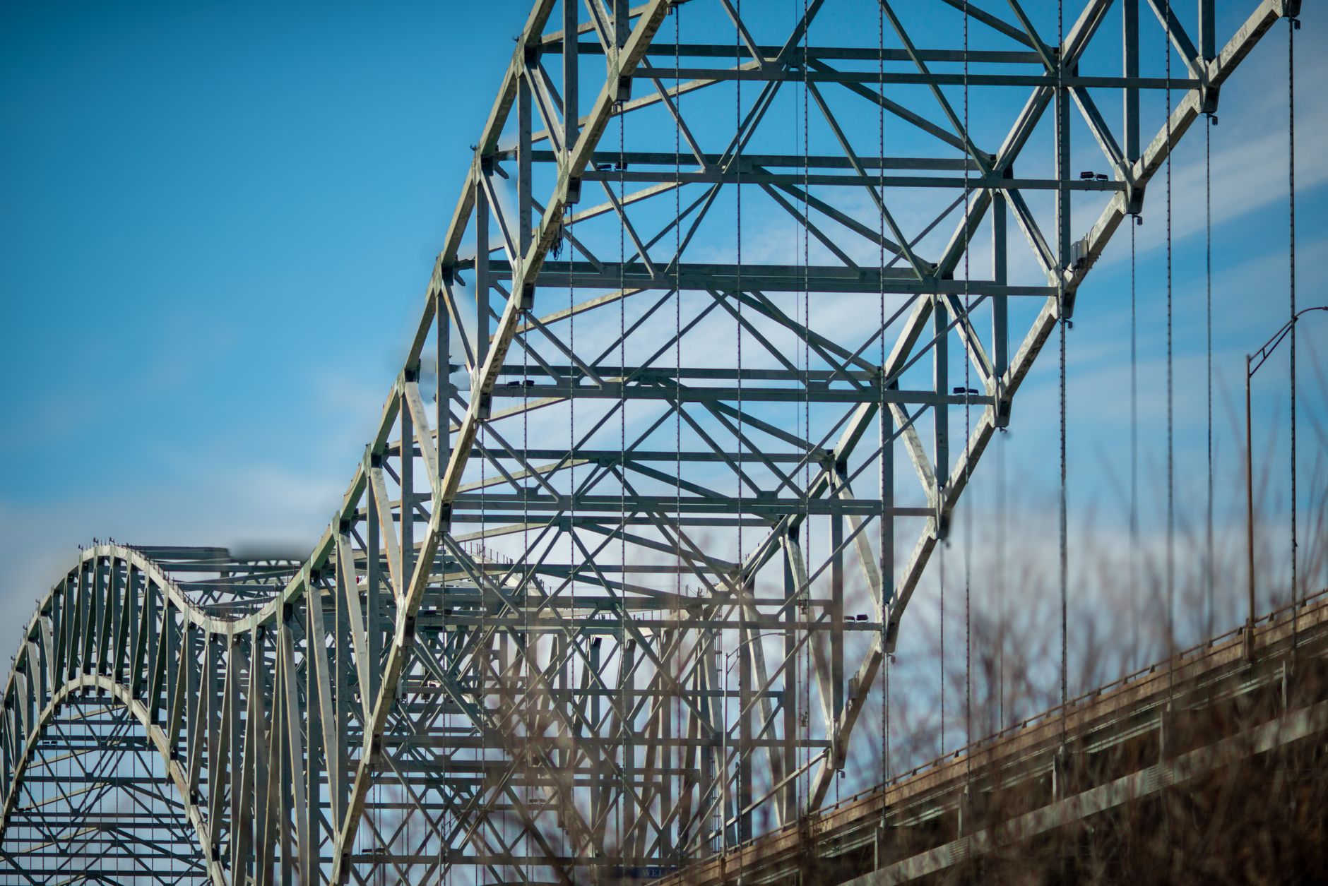 Close up of the Hernando de Soto Bridge's steel arches under a blue sky in Memphis, TN