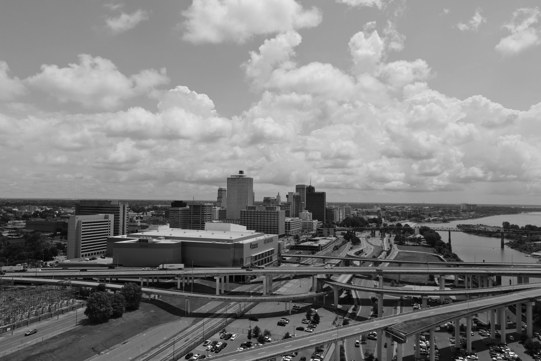Black and white aerial view of the Memphis skyline with prominent roads and clouds in the background