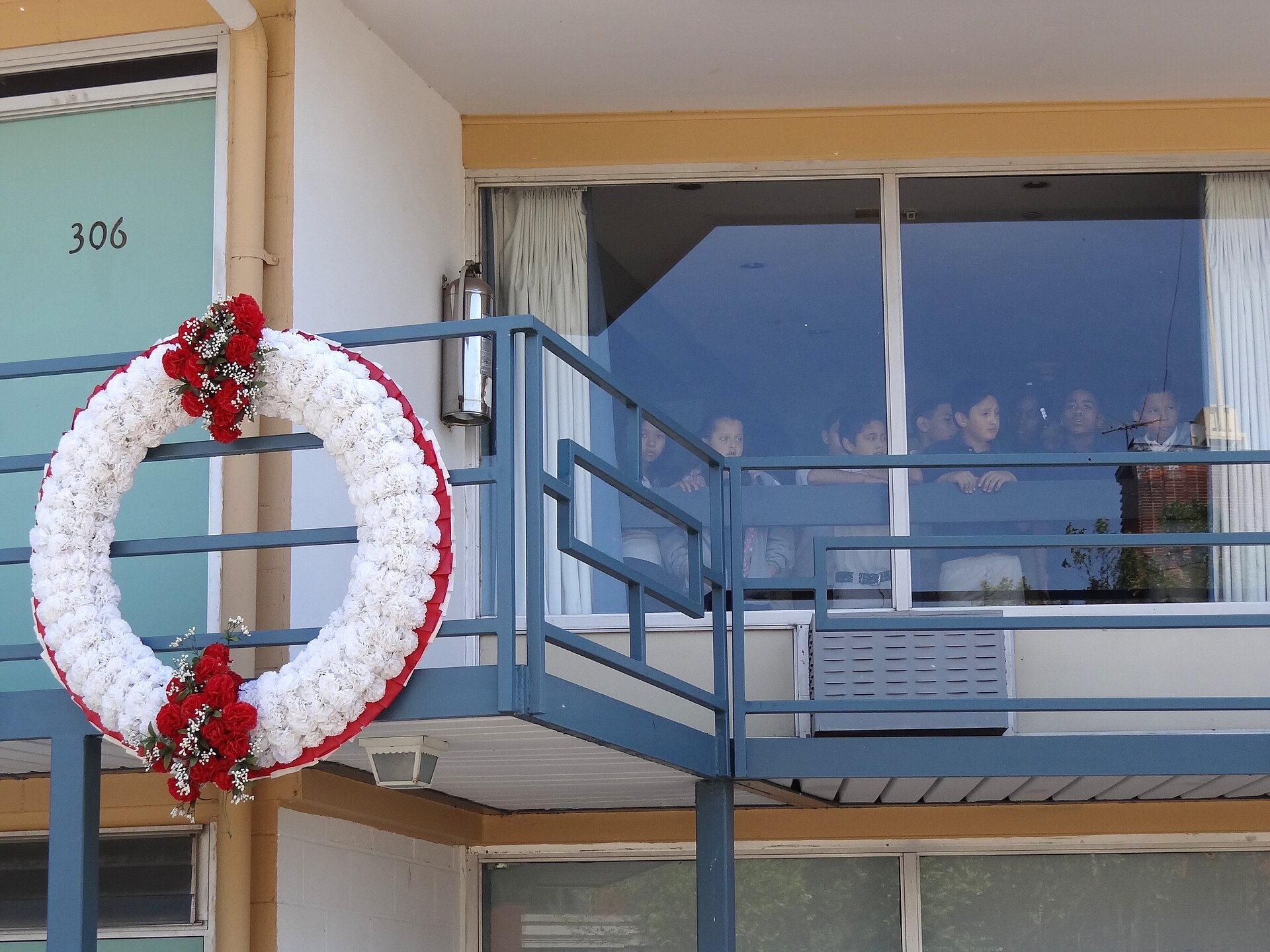 Visitors to the National Civil Rights Museum look out from a window outside MLK's room at the Lorraine Motel in downtown Memphis