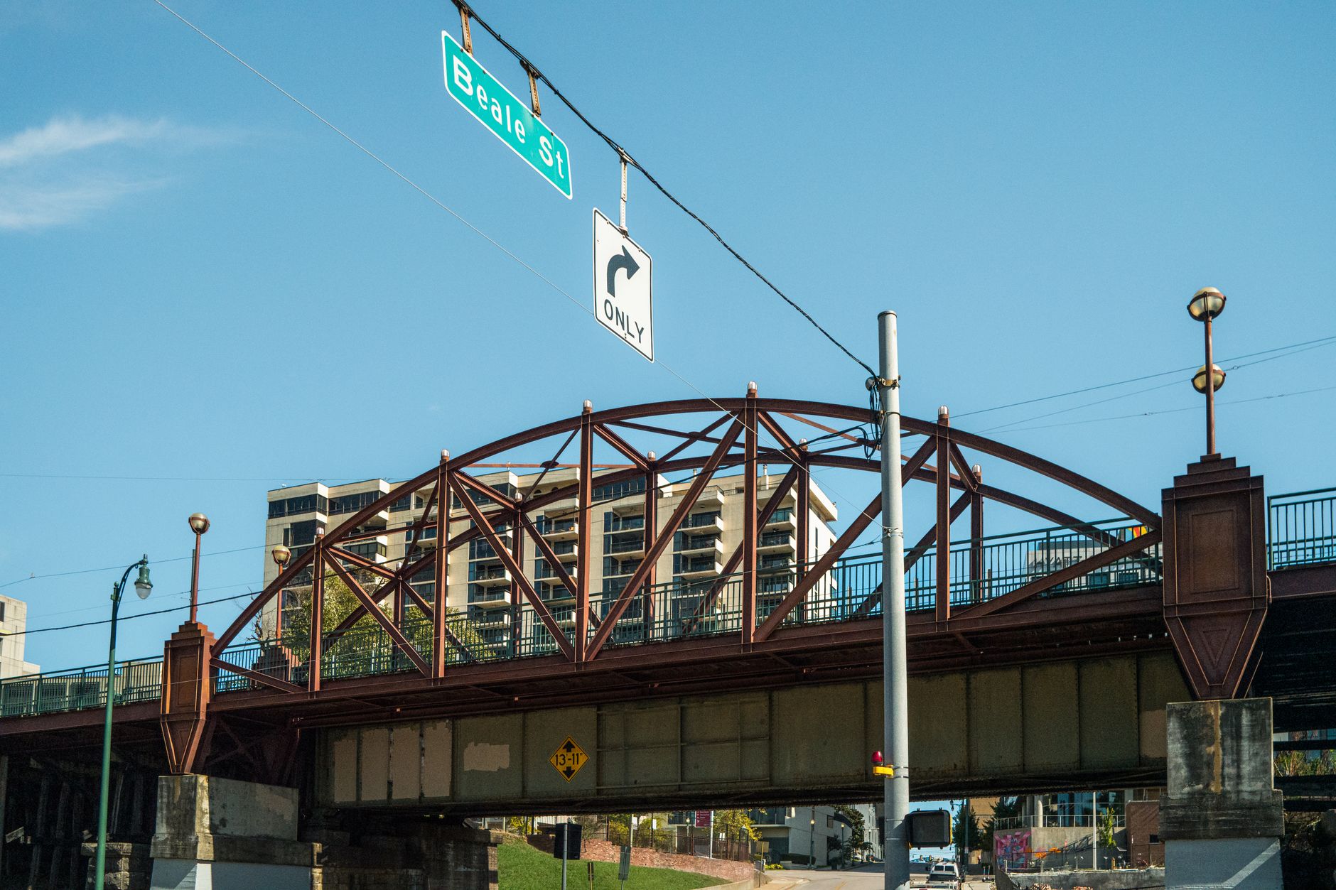 View of the Beale Street bridge in Memphis with cityscape backdrop under clear blue skies