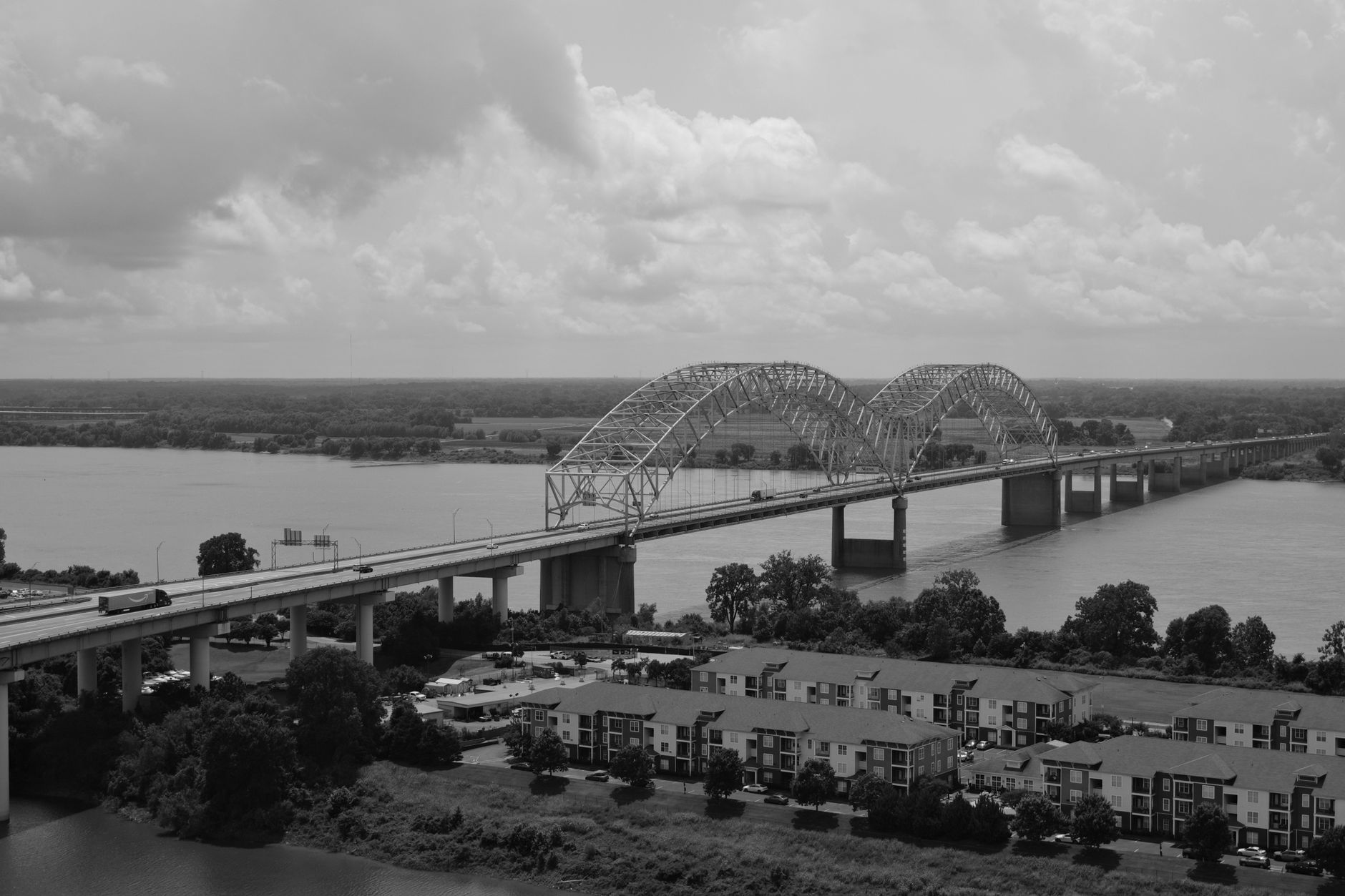 A black and white aerial view of Hernando de Soto Bridge spanning the Mississippi River in Memphis
